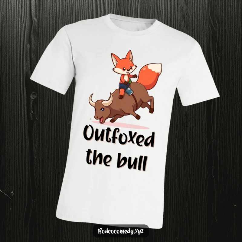 Funny red fox in chaps, attempting to mount a bucking mechanical bull, on a humorous t-shirt, depicting a rodeo challenge.
